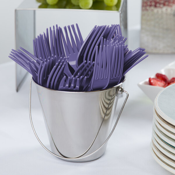 A bucket of purple plastic forks.