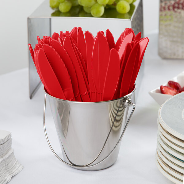 A bucket of Creative Converting classic red plastic knives.