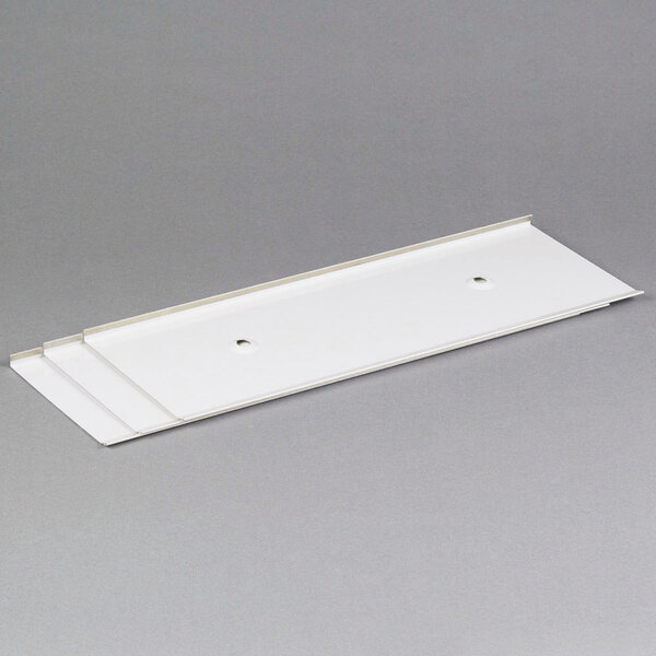 A white rectangular plastic shield with two holes.