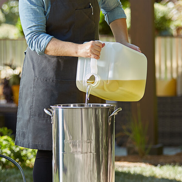 A woman pouring Non-GMO Soybean Oil into a pot.