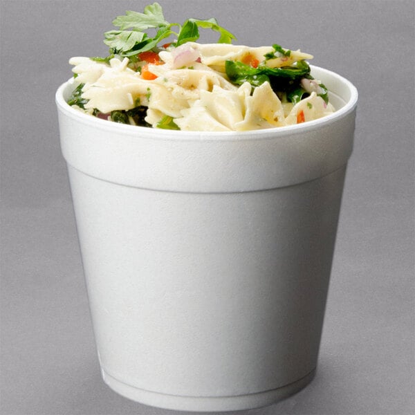 A Dart white foam food container filled with pasta and vegetables.