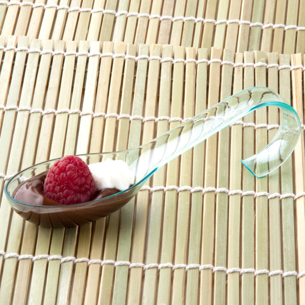 A Fineline Tiny Temptations green plastic spoon with chocolate pudding and a raspberry.