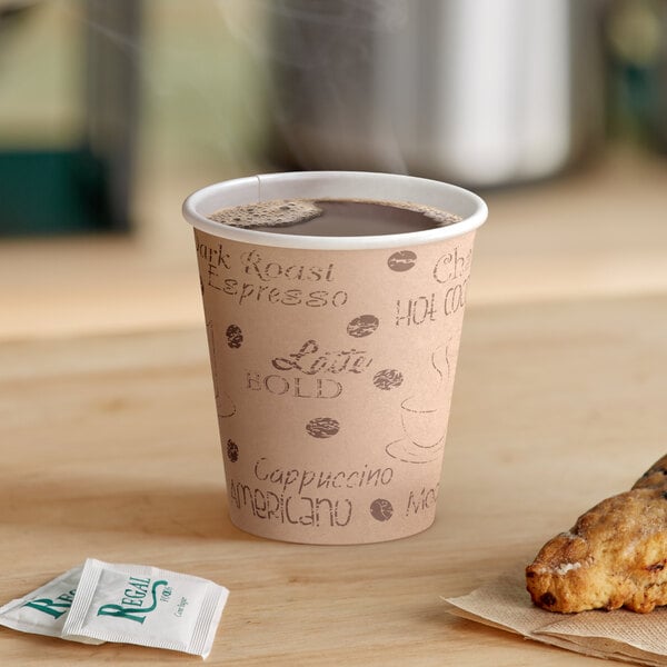 A Choice Cafe Print paper hot cup filled with coffee on a table with a cookie.