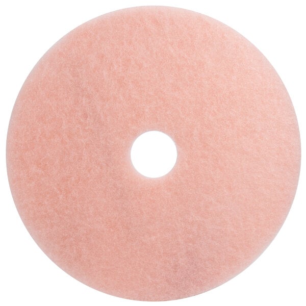 A close-up of a 3M pink circular burnishing pad with a hole in the middle.