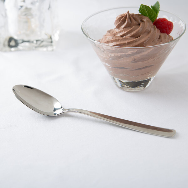 A glass bowl with chocolate mousse and an Arcoroc stainless steel dessert spoon.