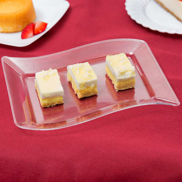 A clear Fineline plastic dessert plate with a piece of cake on it.