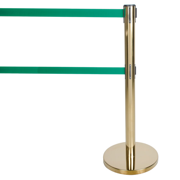 A gold metal Aarco crowd control stanchion pole with green tape.