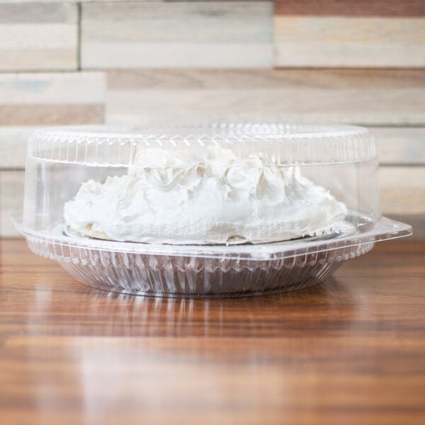A pie in a Polar Pak clear plastic container with a high dome lid on a table.
