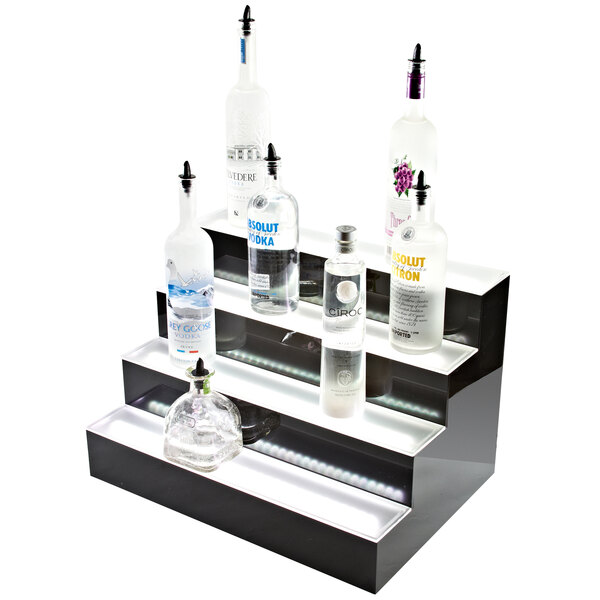 A Beverage-Air three-tiered liquor display with clear bottles on a counter.
