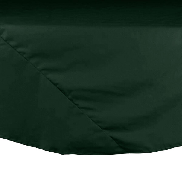 A close up of a hunter green hemmed table cover.