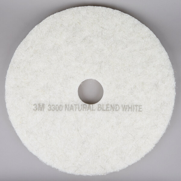 A white circular 3M natural blend white burnishing floor pad.