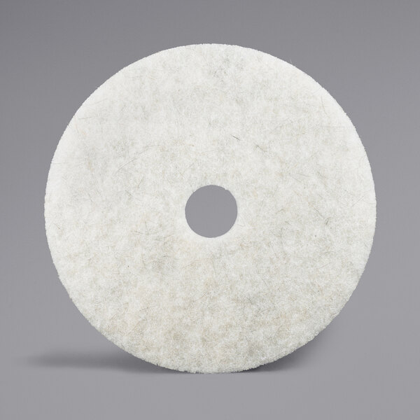A white circular 3M burnishing floor pad with a hole in the center.