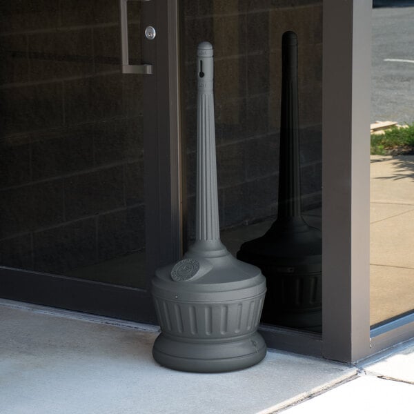 A grey Commercial Zone Smokers' Outpost cigarette receptacle with a round cap on top.