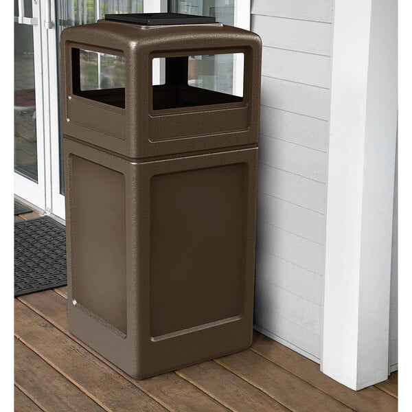 A brown Commercial Zone PolyTec waste container with ashtray dome lid on a porch.