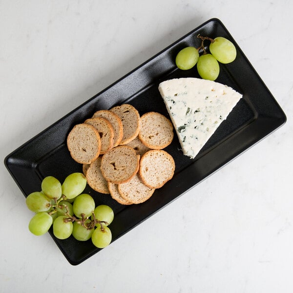A Hall China black rectangular platter with food, bread, and grapes.