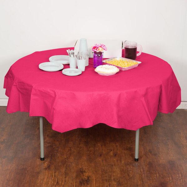 A table with a pink Creative Converting tablecloth, plates, and cups.