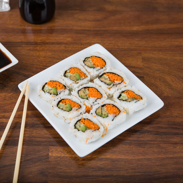 A Libbey Ultra Bright White Coupe Square porcelain plate with sushi on it.