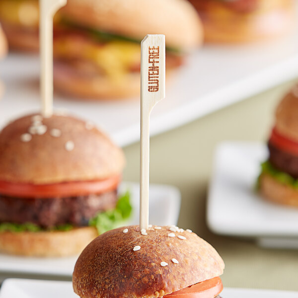 A plate of burgers with Tablecraft gluten-free food picks on a table.