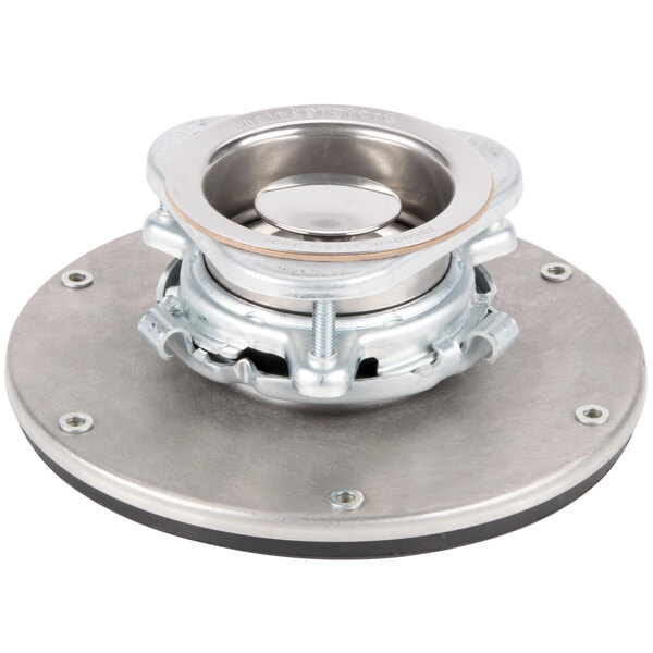 A metal InSinkErator sink flange mounting assembly with a round base.