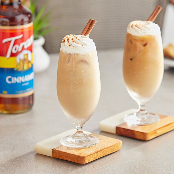 Two glasses of iced coffee with Torani Cinnamon Flavoring Syrup and a straw.