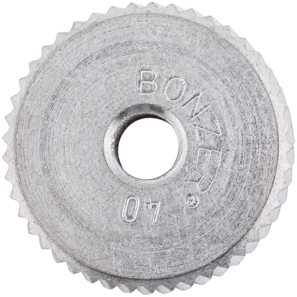 A circular metal Vollrath BCO-10 can opener gear with a hole in the middle and the number 7 on it.