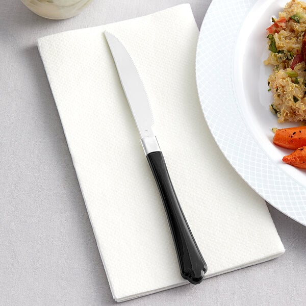 A Visions black plastic knife on a plate of food.