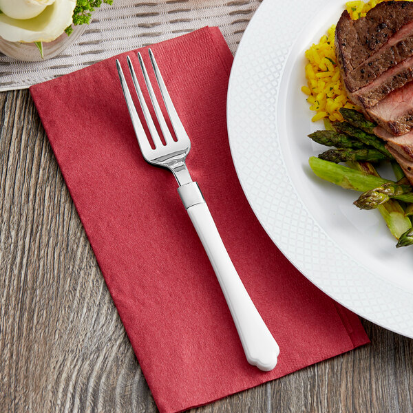 A Visions white plastic fork on a plate with steak and asparagus.