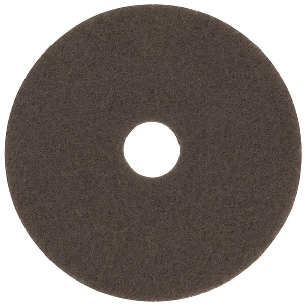 A brown 3M stripping pad with a hole in the middle.