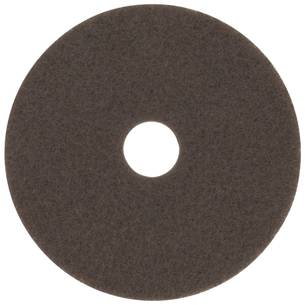 A 3M brown circular stripping floor pad with a hole in the middle.