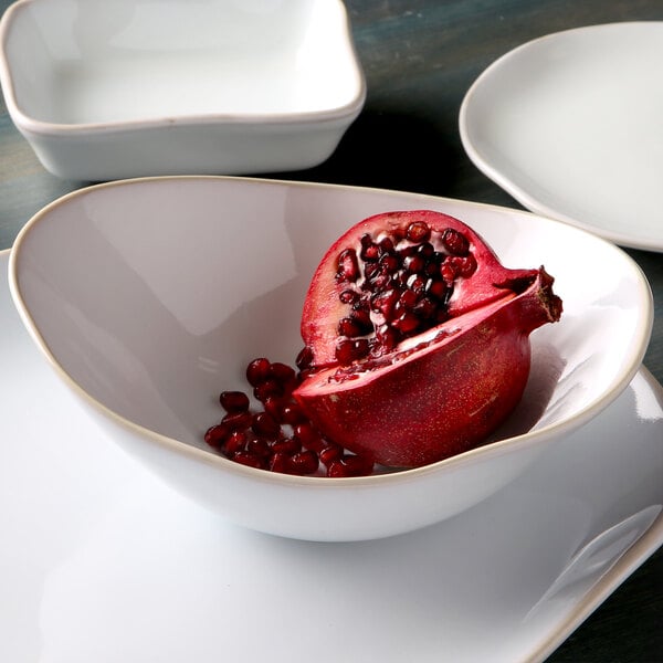 A close-up of a Tuxton Capistrano bowl with a pomegranate in it.