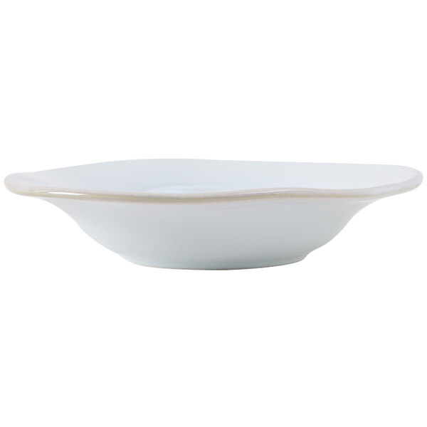 A white Tuxton china soup bowl with a silver rim.