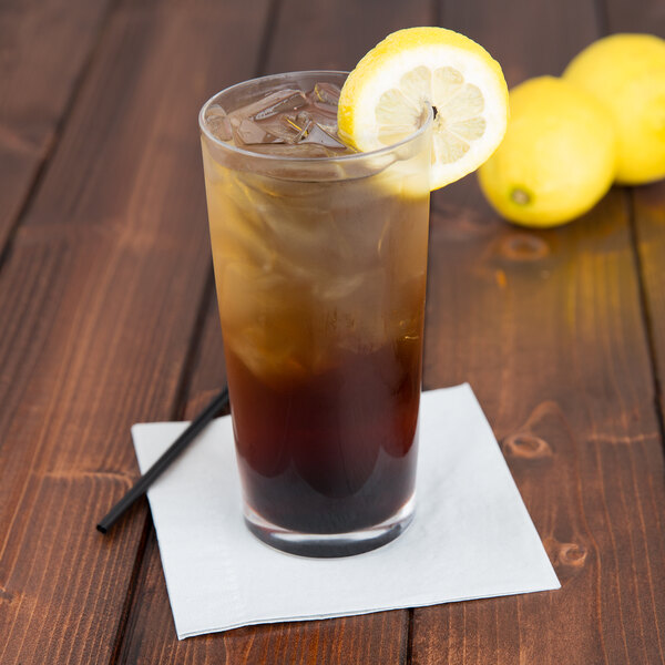 A Spiegelau highball glass of iced tea with a lemon slice and straw.