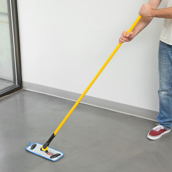 A man using a Rubbermaid yellow microfiber mop handle to clean a floor.