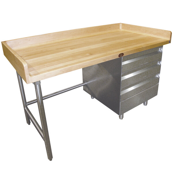 An Advance Tabco wooden baker's table with a galvanized base and drawers.