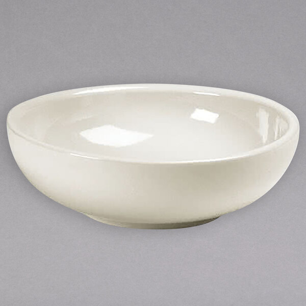 A white Hall China bowl on a gray background.
