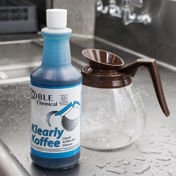 A bottle of Noble Chemical Klearly Koffee liquid coffee pot cleaner on a counter.