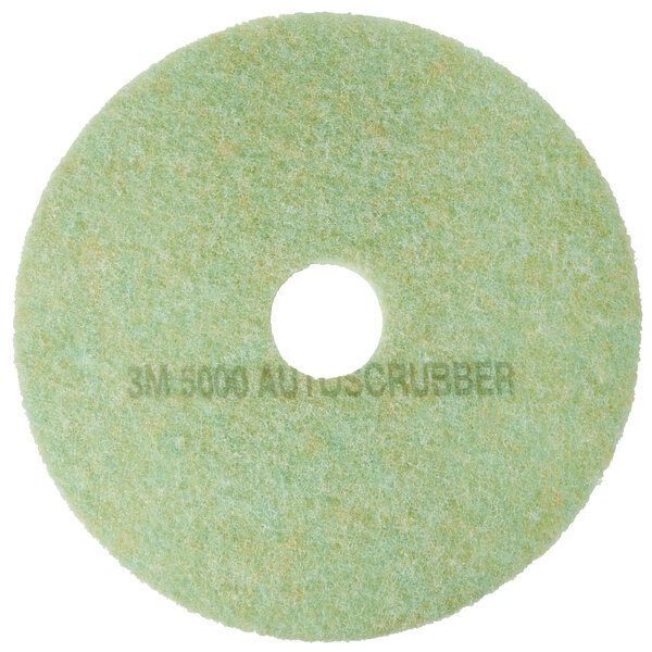 A white circular pad with a green background and a hole in the middle.