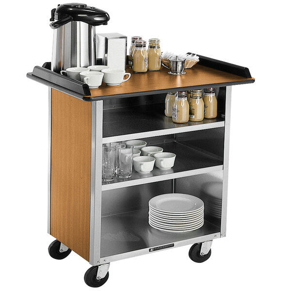 A Lakeside stainless steel beverage service cart with light maple shelves full of cups and sauces.