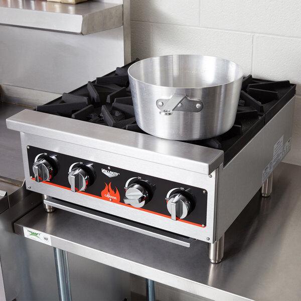 A Vollrath countertop gas range with a pot on top.