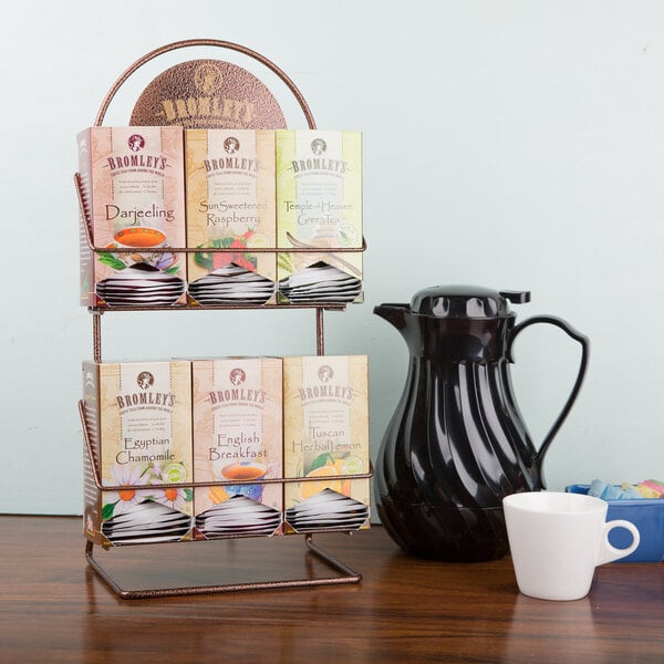 A Bromley tea rack with tea cups and a pitcher on a counter.