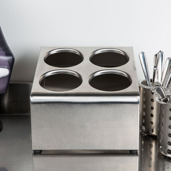 A Steril-Sil stainless steel countertop flatware organizer with four cylinders holding utensils.