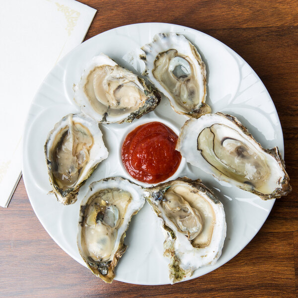 A CAC oyster plate with oysters and red sauce.