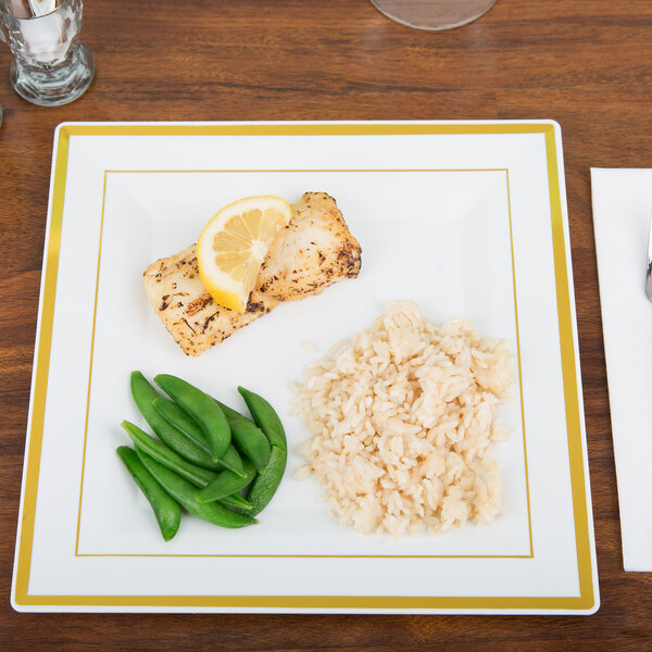 A Fineline Silver Splendor plastic square plate with rice, peas, and a lemon slice on it.
