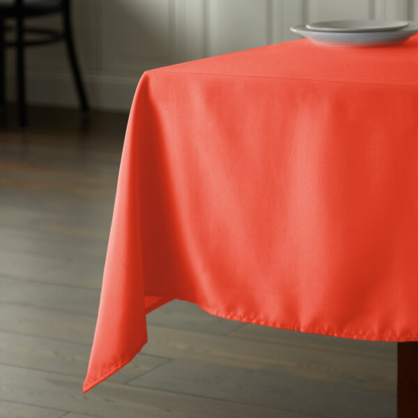 An orange Intedge square tablecloth on a table.