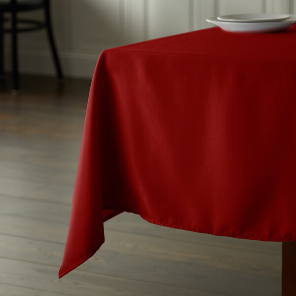 A red Intedge square tablecloth on a table.
