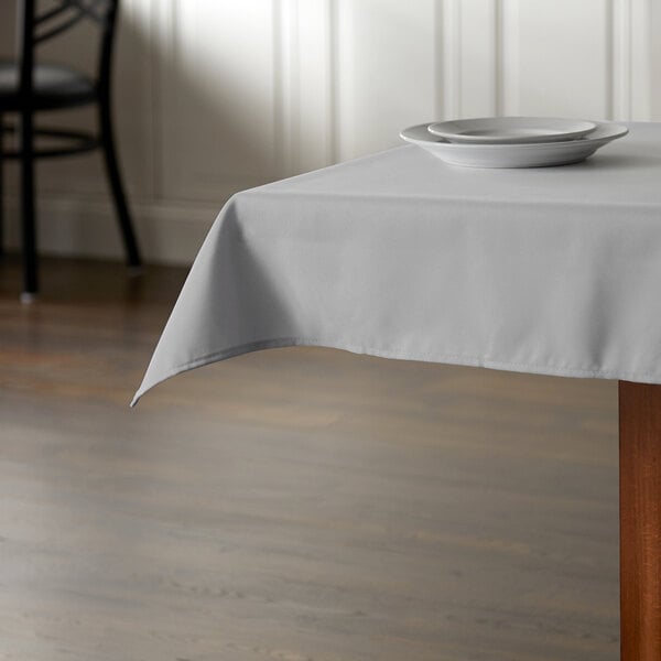 A square gray polyester tablecloth with a white plate on it.