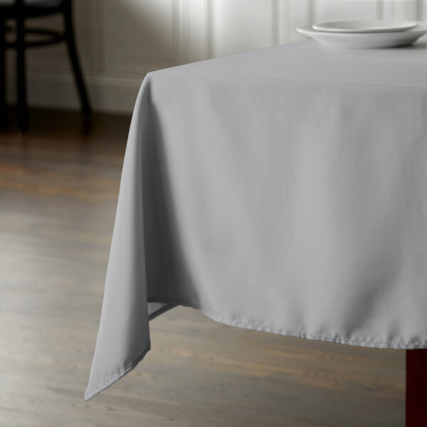A square table with a gray polyester tablecloth on it.
