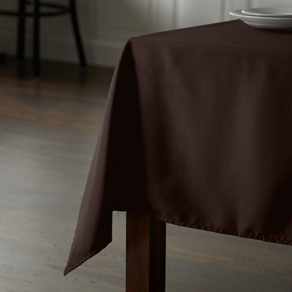 A brown Intedge rectangular table cover on a wooden table.