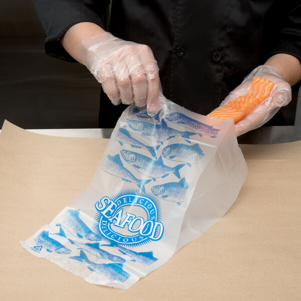 A person in plastic gloves holding a seafood bag with fish images.