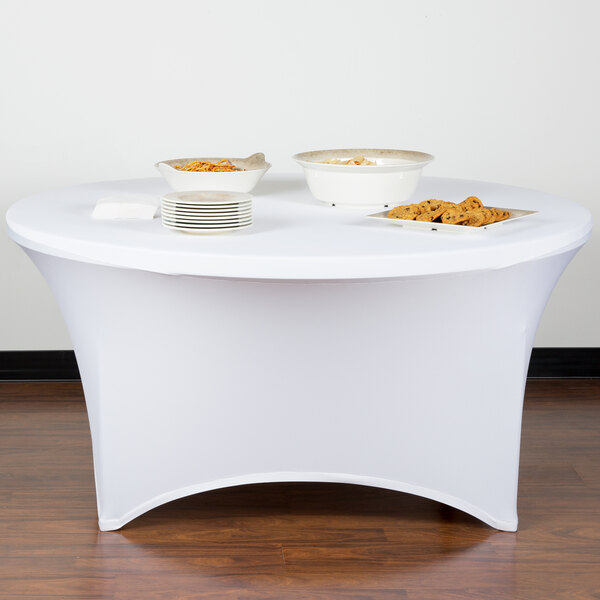 A white Snap Drape spandex table cover on a table with food.